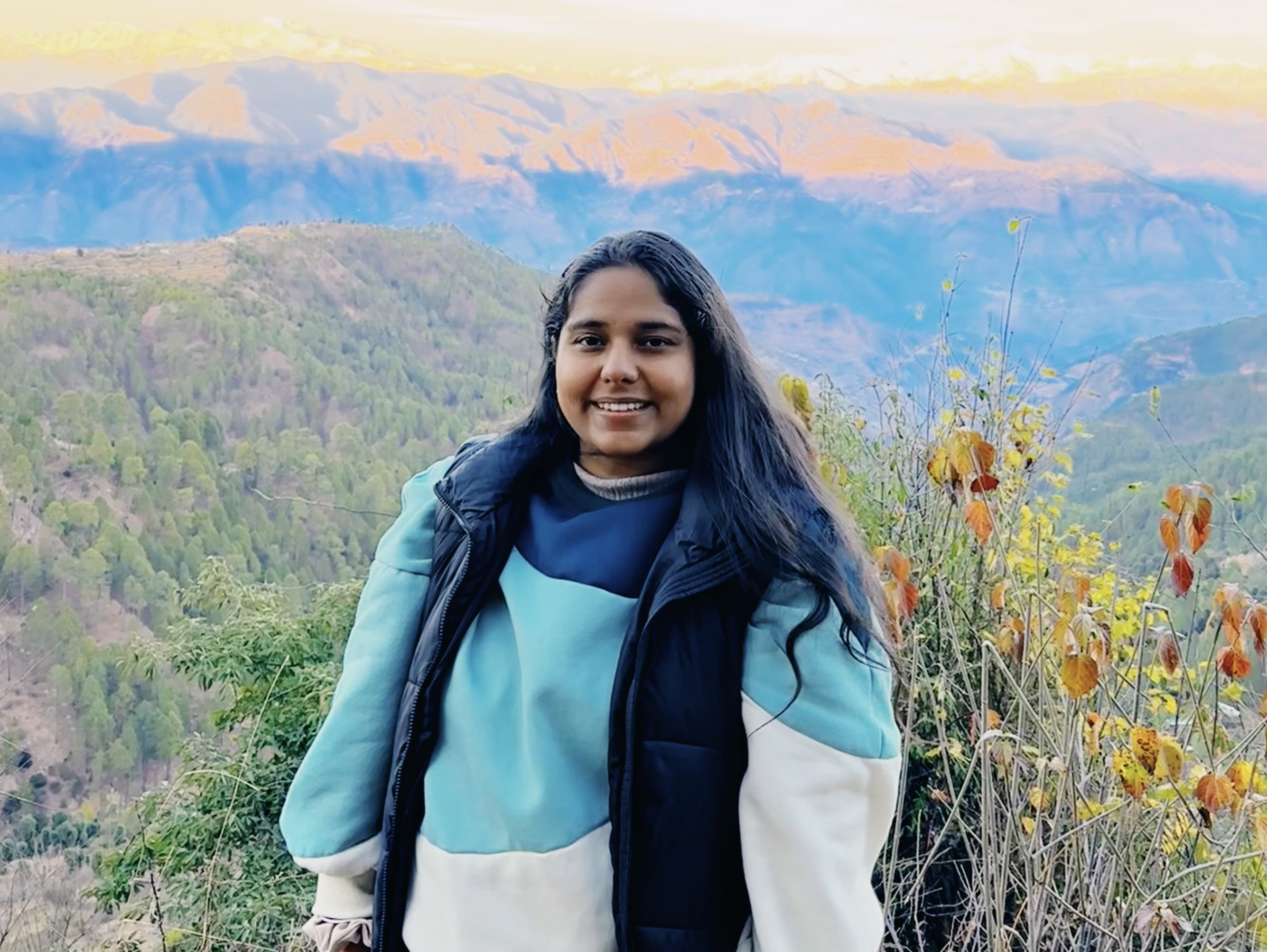 Simran Sethi in the Himalayas, surrounded by majestic mountain peaks